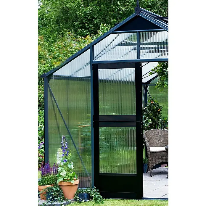 Juliana Gewächshaus Gärtner - Außenmaß inkl. Dachüberstand (B x T): 368 x 439 cm, Material Seitenwand: Kunststoff, 10 mm, Silber/Schwarz - Nahaufnahme eines Gewächshauses mit geöffneter Tür, umgeben von üppigem Grün und Pflanzen in Töpfen.
