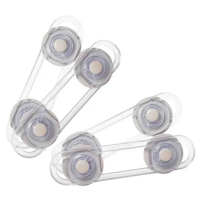Dreambaby Mini-Multifunktionsverschluss - Kleben, Farblos, 4 Stk. - Nahaufnahme von zwei transparenten Schrankschlössern mit Klebefläche für Kindersicherheit mit schwarzem Hintergrund.