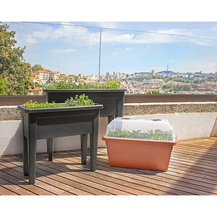 Artevasi Venezia Hochbeet - L x B x H: 80 x 39 x 69 cm, Kunststoff, Anthrazit - Drei ArteVasi Pflanzgefäße in verschiedenen Größen und Farben auf einer Holzterrasse mit Blick auf die Stadt.