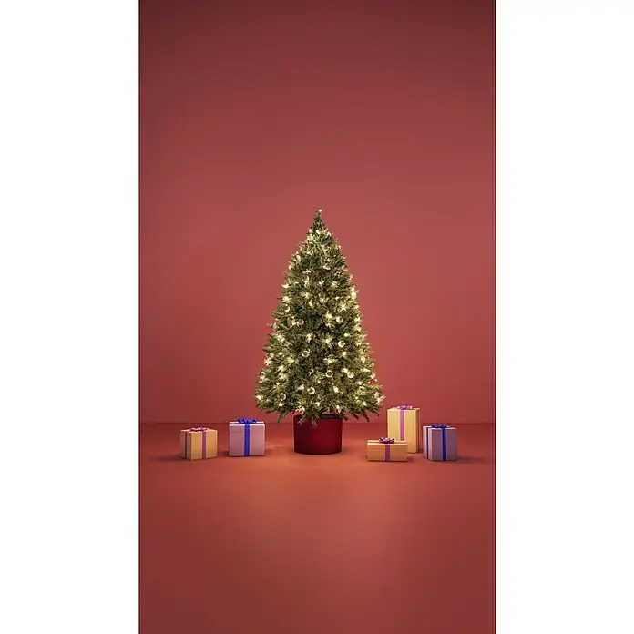 WiZ Guirnalda LED inteligente WiFi - Para interior, 20 m, Color de luz: Multicolor, 160 ud. - Árbol de Navidad con luces cálidas y adornos plateados en una maceta roja, rodeado de regalos sobre un fondo rojo.