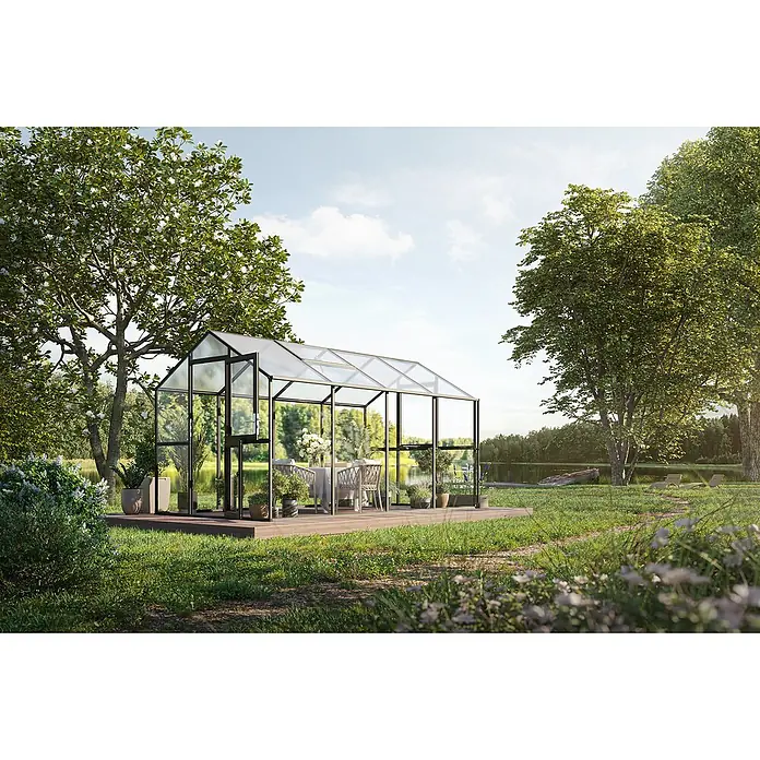KGT Gewächshaus Aptasia IV - Außenmaß inkl. Dachüberstand (B x T): 233 x 429 cm, 4 mm, Anthrazit-Grau - Ein elegantes Gewächshaus mit klaren Glaswänden und schwarzem Rahmen steht auf einer Holzterrasse in einem Garten.