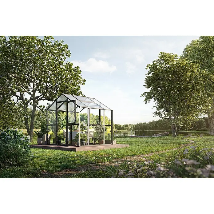 KGT Gewächshaus Aptasia Typ III – small - Außenmaß inkl. Dachüberstand (B x T): 233 x 217 cm, Material Seitenwand: Glas, 4 mm, Anthrazit-Grau - Ein elegantes Gewächshaus mit schwarzem Rahmen steht auf einer Holzterrasse, umgeben von üppigem Grün und Bäumen.
