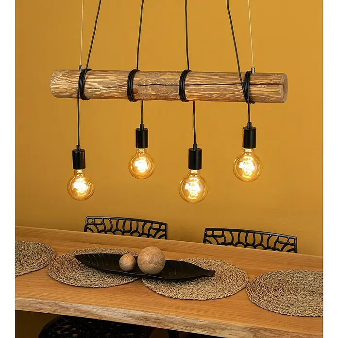 Pendelleuchte Towny - 240 W, B x L: 70 x 140 cm, Schwarz, E27 - Eine rustikale Hängelampe aus Holz mit vier Glühbirnen beleuchtet einen Esstisch mit natürlicher Dekoration.