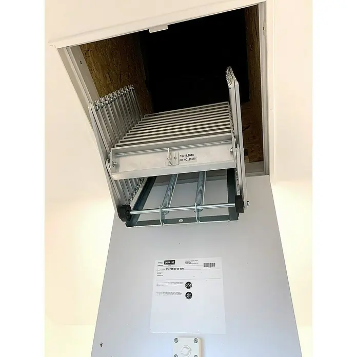 Dolle Bodentreppe Alu fix mit Stirnbrett - Anzahl Stufen: 9 Stk., Passend für: Vorhandene Luken ab 65 x 55 cm - Bild einer ausziehbaren Dachbodentreppe aus Metall, die an einer weißen Luke befestigt ist und in einen dunklen Dachboden führt.