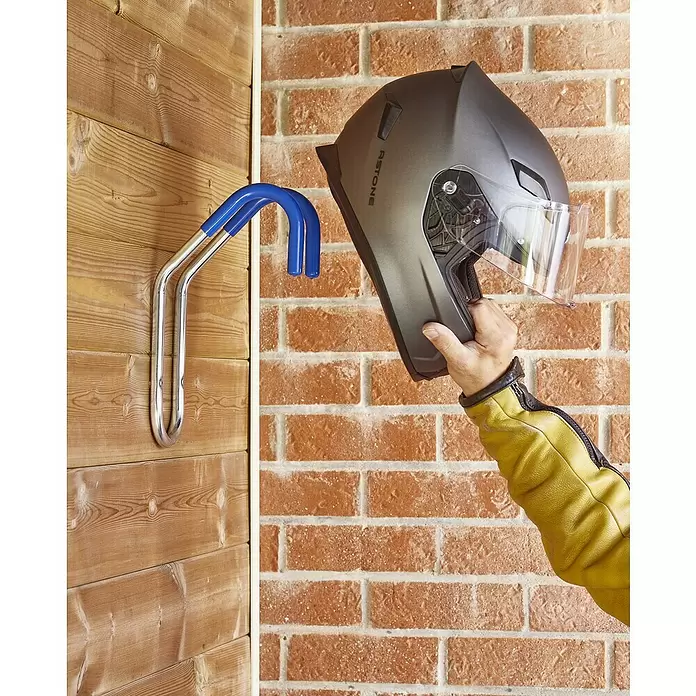 Mottez Gancho de pared para bicicletas - Diámetro: 16 mm, Acero, Plateado - Gancho metálico azul y cromado montado en la pared, diseñado para cascos de moto, mostrado en una pared de madera.