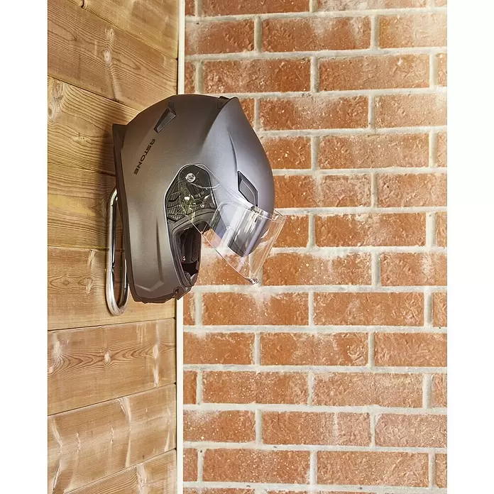Mottez Gancho de pared para bicicletas - Diámetro: 16 mm, Acero, Plateado - Casco de moto gris oscuro con visera transparente, colgado de un gancho cromado en una pared de madera.