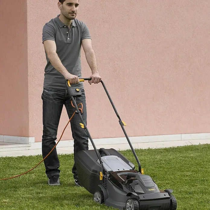 Alpina Cortacésped eléctrico BL320E - 1.000 W, Ancho de corte: 32 cm - Un hombre corta el césped con un cortacésped eléctrico Alpina, ideal para jardines pequeños.