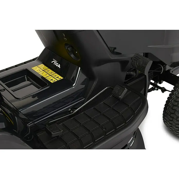 Alpina Rasentraktor AT4 98 HWA - 10,4 kW, 586 cm³, Schnittbreite: 98 cm, Max. Flächenempfehlung: 4.500 m² - Detailansicht eines STIGA Aufsitzmähers, die das Fußpedal und die Sicherheitsaufkleber hervorhebt.