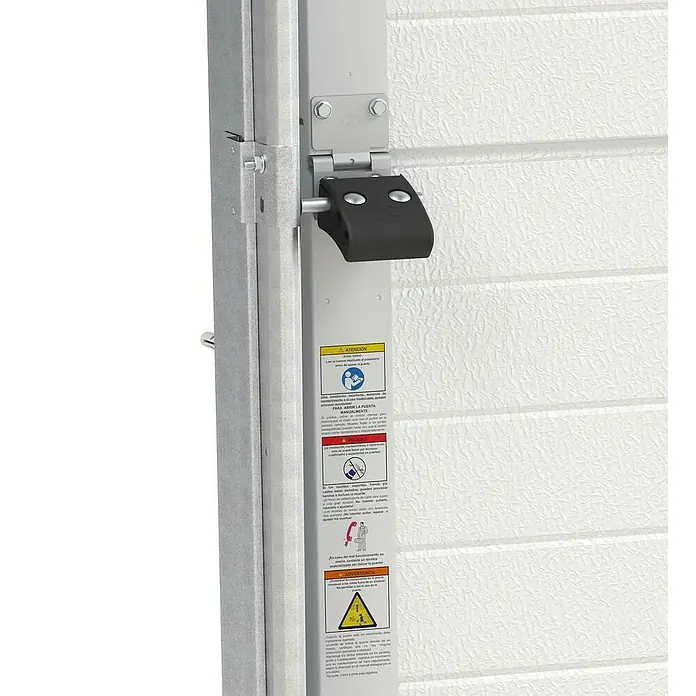 Solid Elements Puerta de garaje seccional PRO - 250 x 212,5 cm, Blanco, Peatonal - Primer plano de una bisagra de puerta de garaje con etiquetas de advertencia en un panel blanco y texturizado.