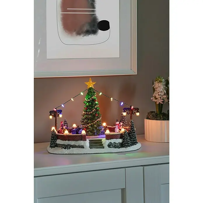 Konstsmide LED-Weihnachtsdorf Dorfplatz mit Musik - Bunt, 31,5 x 19 x 21 cm, LED, Batteriebetrieben - Festliche Weihnachtsdekoration mit beleuchtetem Weihnachtsbaum, Schneemann und Laternen, die eine warme, einladende Atmosphäre schafft.