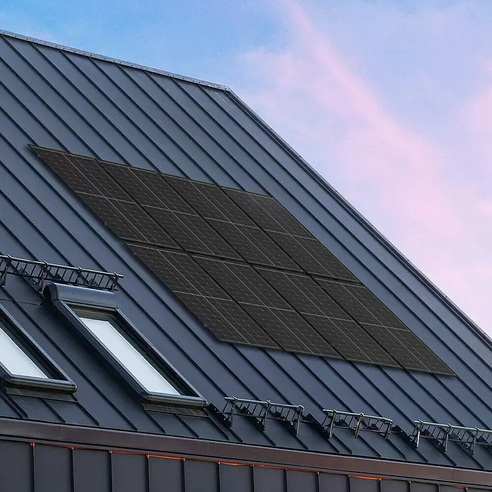 Green Solar Universalhalterung - Passend für: 18 Solarmodule - Schwarze Solarmodule auf einem dunkelgrauen Metalldach mit Dachfenstern.