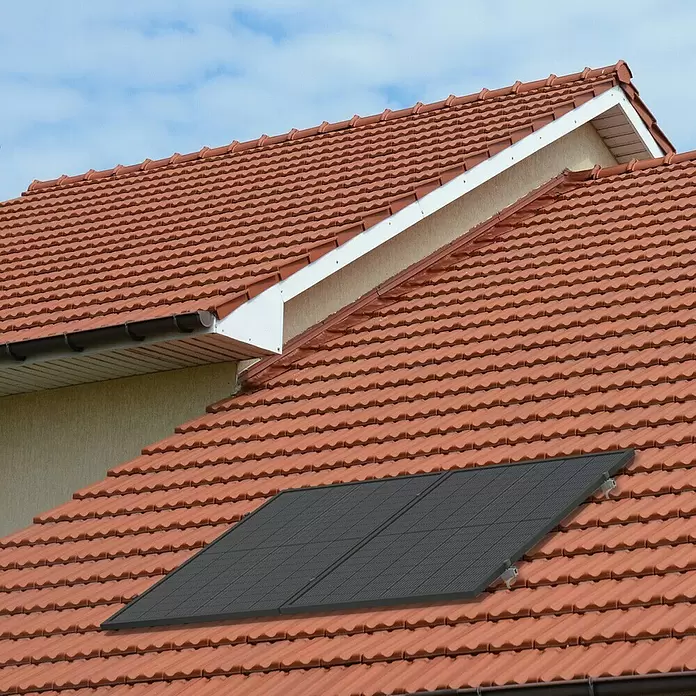 Green Solar Solarmodul-Set 0% MwSt. gem. § 12 Abs. 3 UStG - Nennleistung: 450 W, L x B x H: 176,2 x 113,4 x 3 cm, 1 Stk. - Zwei schwarze Solarpaneele auf einem terrakottafarbenen Ziegeldach unter blauem Himmel.