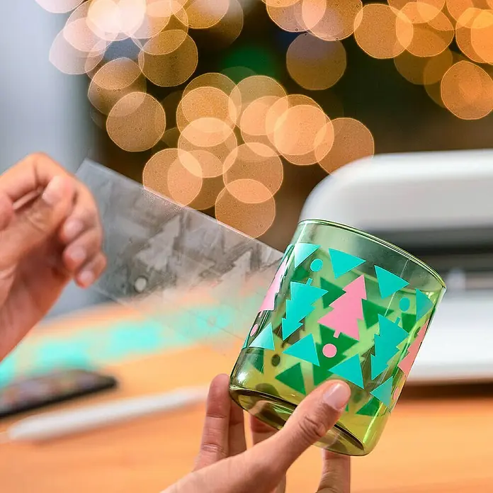 Cricut Maker Schneideplotter Maker 3 - Blau, Bluetooth, Schnittbreite: 29,7 cm, Schnittlänge: 3,6 m - Individuell gestaltetes Glas mit Weihnachtsbaum-Motiv, verziert mit blauen und rosa Akzenten. Perfekt für festliche Getränke und Deko.