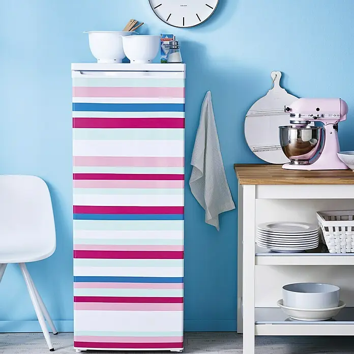 D-c-fix Rollo adhesivo - 200 x 45 cm, Magenta, Autoadhesivo - Frigorífico combi a rayas en un espacio de cocina luminoso, que ofrece una solución de refrigeración lúdica y funcional.