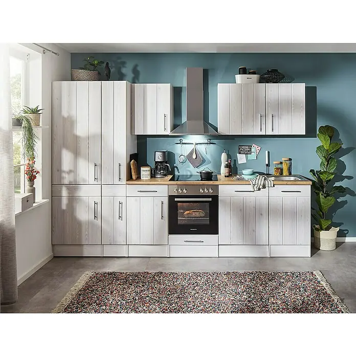 Respekta Premium Küchenzeile Anton - Breite: 310 cm, Weiß, Mit Elektrogeräten - Moderne Küche mit weißen Holzschränken, integriertem Ofen und Edelstahl-Dunstabzugshaube vor einer türkisfarbenen Wand.