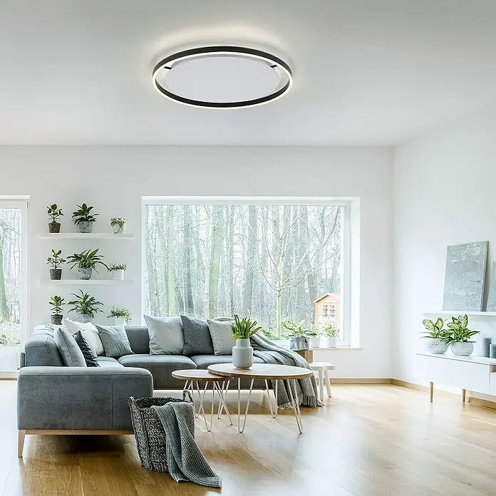 Just Light Ritus Plafón LED redondo - L x An x Al: 58,5 x 58,5 x 5,3 cm, Blanco cálido - Un salón moderno con una lámpara de techo redonda con borde negro, que irradia una luz brillante y acogedora. La lámpara armoniza con el interior.