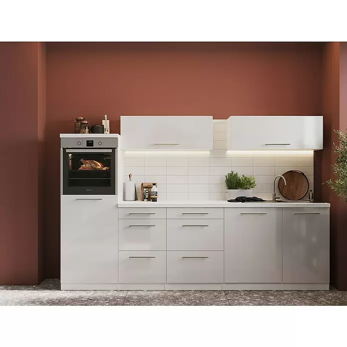 Respekta Premium Cocina de isla Amanda - Ancho: 280 cm, Blanco, Con electrodomésticos - Muebles de cocina blancos modernos con encimera clara, horno y fregadero integrados, sobre una pared marrón rojiza cálida.
