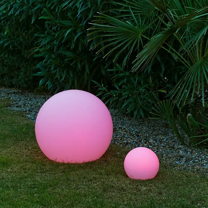 New Garden Design-Außenleuchte Buly 50 - Durchmesser: 50 cm, E27, IP65 - Zwei leuchtende rosa Kugelleuchten unterschiedlicher Größe auf einer Rasenfläche vor üppigem Grün.