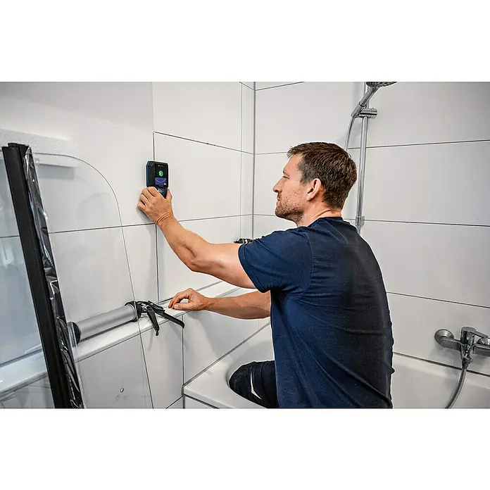 Bosch Professional Ortungsgerät GMS 120-27 - Erfassungstiefe: Max. 120 mm NE-Metalle - Ein Mann installiert eine Duschwand im Badezimmer mit einem digitalen Messgerät zur präzisen Ausrichtung.