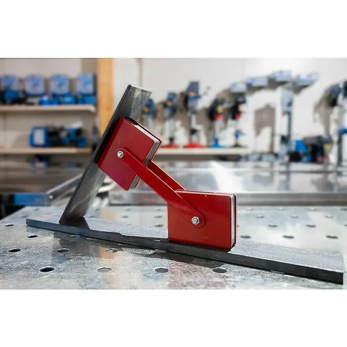 Güde Schweiß-Winkelmagnet - 1 Stk. - Roter Schweißwinkelmagnet hält zwei Metallstücke in einem 90-Grad-Winkel auf einem Lochtisch. Präzises Schweißen dank Magnetkraft.