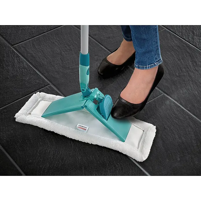 Leifheit Bodenwischer Classic XL Microfibre Tele - 42 cm, 58 % Polyester, 42 % Baumwolle - Nahaufnahme eines Leifheit Bodenwischers mit Mikrofaserbezug auf dunklem Fliesengrund, bedient von einer Person in Jeans und schwarzen Schuhen.