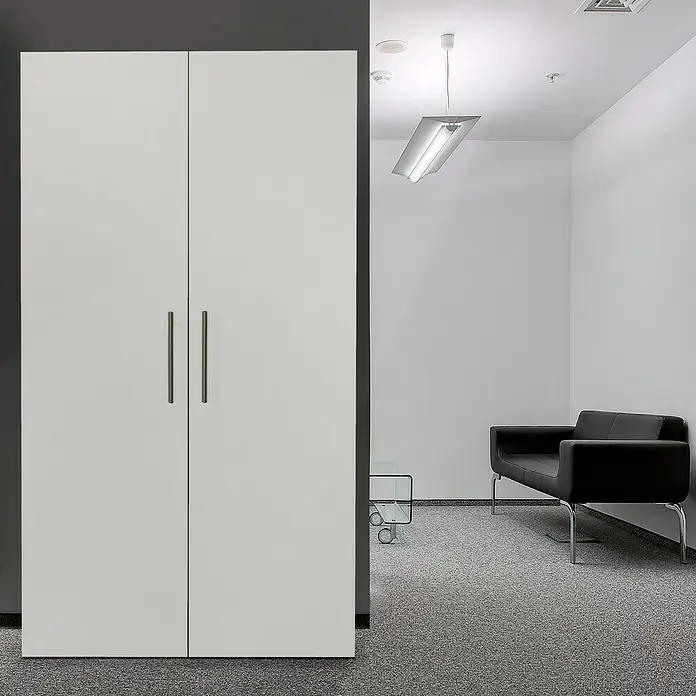 Respekta Schrankküche Peter - Breite: 104 cm, Weiß, Mit Glaskeramikkochfeld - Das Bild zeigt einen modernen Büroraum mit einem großen, weißen Flügeltürenschrank, einem schwarzen Sofa und einem Glastisch auf einem grauen Teppichboden.