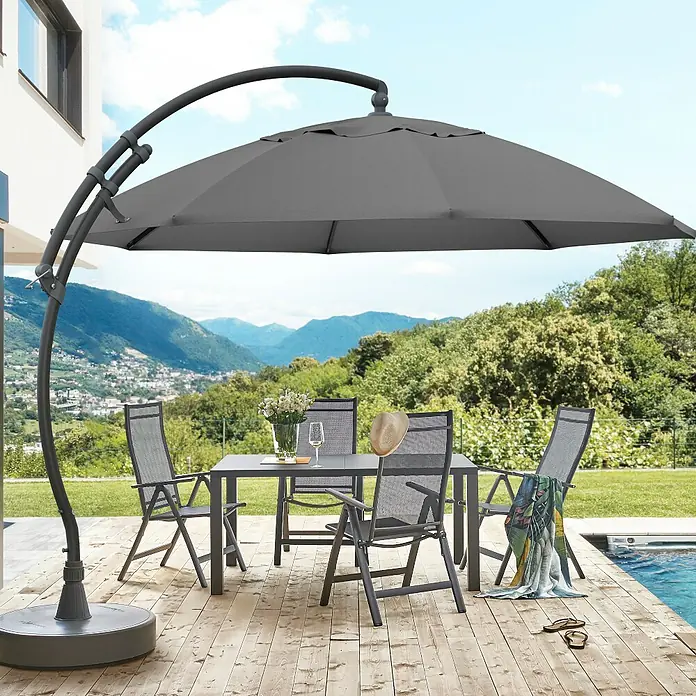 Sun Garden Ampelschirm rund Easy Sun - Grau-meliert, Durchmesser Bespannung: 375 cm - Gartentisch mit Sonnenschirm. Das graue Sonnenschirmset bietet Schatten für Mahlzeiten im Freien auf einer Holzterrasse mit Poolblick.
