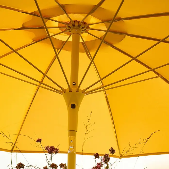 Siena Garden Marktschirm rund Paolo - Curry, Durchmesser Bespannung: 270 cm - Nahaufnahme eines gelben Sonnenschirms von unten, der die Struktur und das Design des Schirms hervorhebt.
