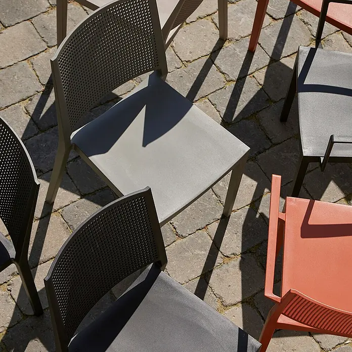Siena Garden Urban Lights Stapelstuhl Square - Polypropylen, Stapelbar, Taupe, B x T x H: 46 x 56 x 80 cm - Gartenstühle aus Kunststoff in Grau-, Schwarz- und Rottönen auf Steinboden, die durch ihr modernes Design bestechen.