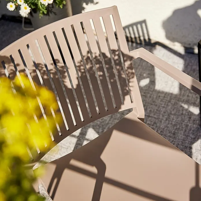 Siena Garden Urban Lights Stapelsessel Lane - Polypropylen, Stapelbar, Taupe, B x T x H: 57 x 56 x 80 cm - Nahaufnahme eines beigen Gartenstuhls mit Lattenmuster und Armlehnen, teilweise beschattet.