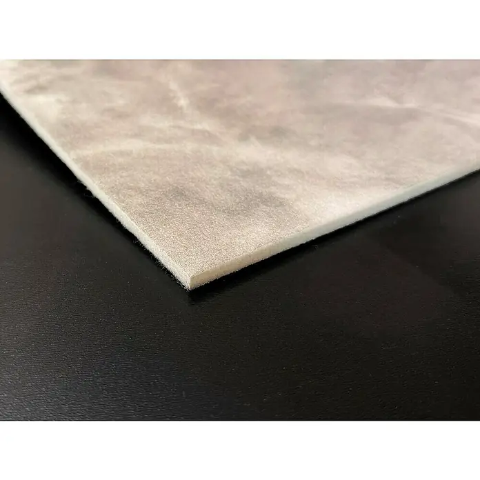 Bariperfil Panel acústico decorativo Acoustic Wall Calima - 260 x 60 x 0,65 cm, Gris - Primer plano de una placa de espuma marmolada clara sobre una superficie negra lisa, ideal para aislamiento y amortiguación.