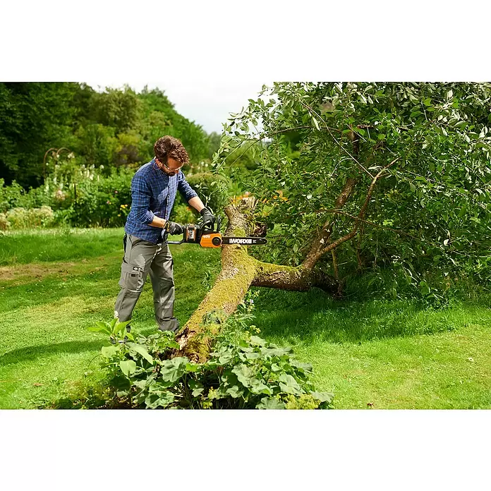 Worx PowerShare 20V Akku-Kettensäge WG384E.9 - Akkuspannung: 40 V, Li-Ionen, Ohne Akku, 35 cm - Mann zersägt mit einer orange-schwarzen WORX Kettensäge einen moosbewachsenen Baumstamm im Freien.