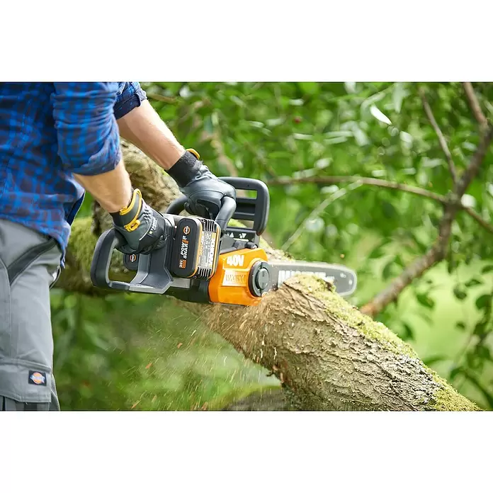 Worx PowerShare 20V Akku-Kettensäge WG384E.9 - Akkuspannung: 40 V, Li-Ionen, Ohne Akku, 35 cm - Person schneidet mit orange-schwarzer Akku-Kettensäge einen bemoosten Ast, Holzspäne fliegen.