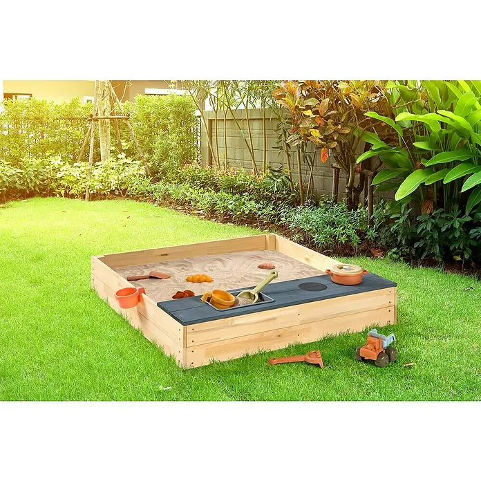 Sun Sandkasten Matschkiste - 100 x 100 x 19 cm, Holz, Natur/Grau - Ein hölzerner Sandkasten mit Spielzeug steht auf einer grünen Wiese im Garten, ideal für Kinder zum Spielen und Spaß haben im Freien.