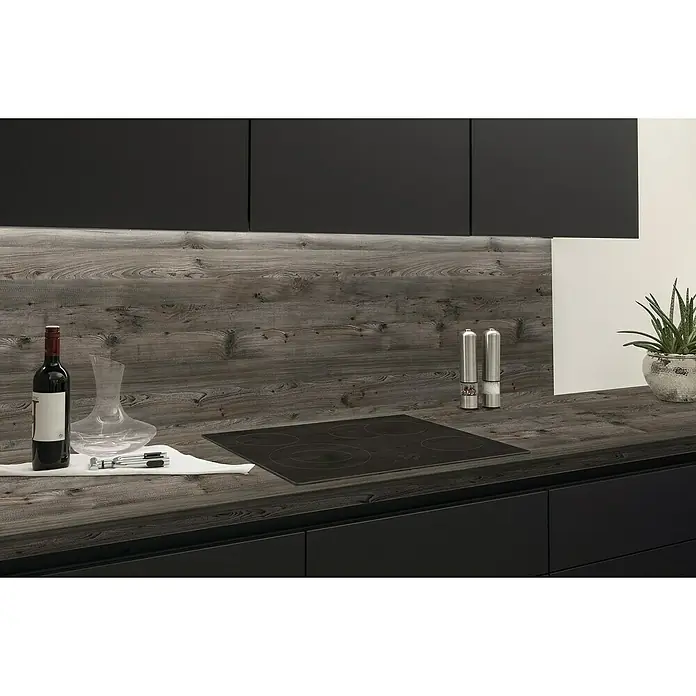 LOGOCLIC Küchenrückwand Fixmaß - Arizona Pine/Hemlock Lava, 410 x 64 cm, Stärke: 13,4 mm - Küchenansicht mit schwarzem Induktionskochfeld und passenden Schränken, akzentuiert durch eine Weinflasche und diverse Küchenutensilien.