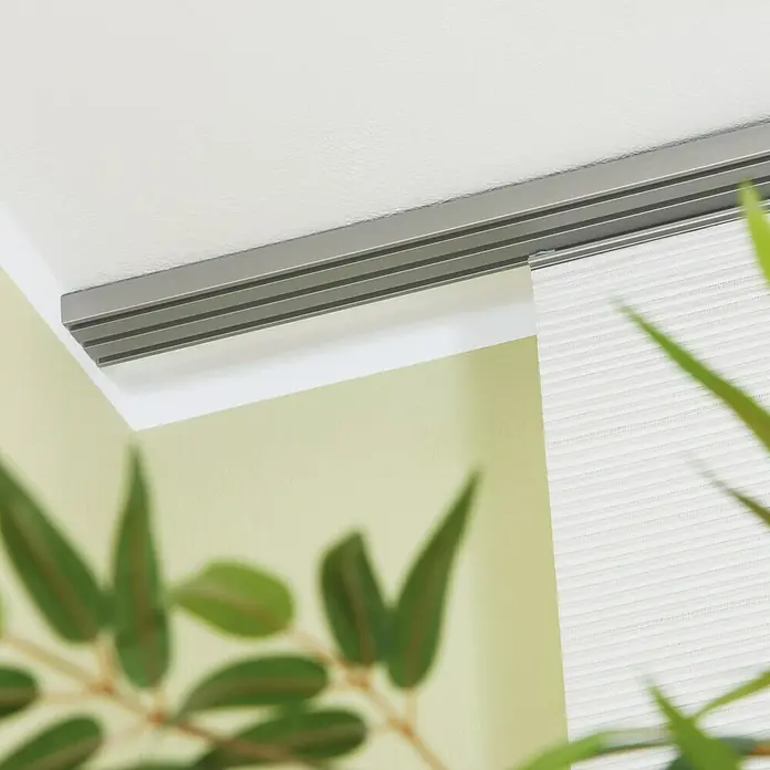 Flächenvorhangschiene - Anzahl Läufe: 3 Stk., Silber, 210 cm - Nahaufnahme einer Gardinenschiene in Silber, die an einer hellen Wand befestigt ist und eine stilvolle Fensterdekoration darstellt.