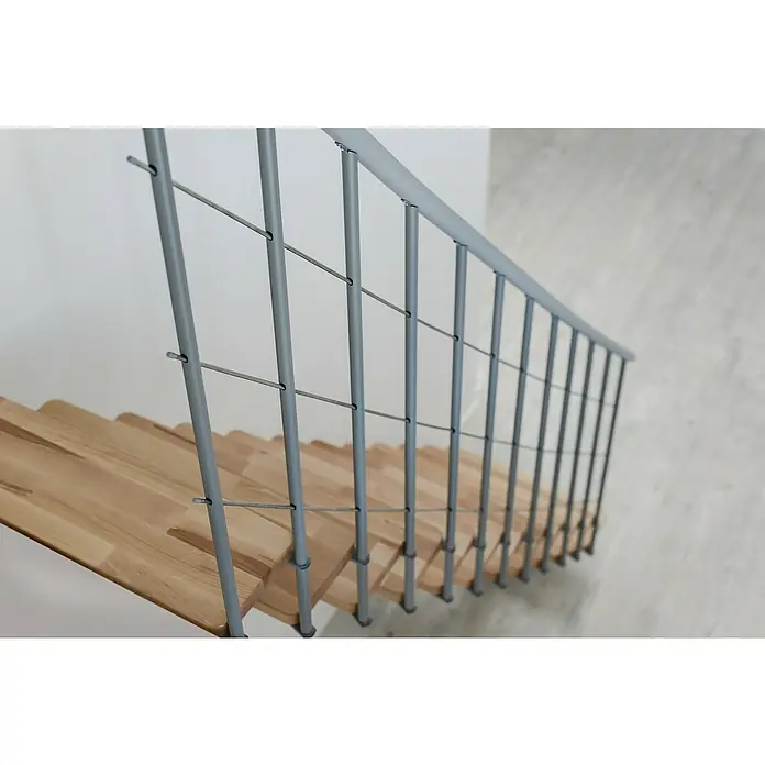 Minka Mittelholmtreppe Comfort Top - Breite: 80 cm, Grau, Farbe Stufen: Buche Natur, Geschosshöhe: 312 cm - Die Aufnahme zeigt eine Treppe mit einem modernen Geländer aus grauem Metall, welches durch horizontale Drähte ergänzt wird, was ein minimalistisches Design erzeugt.