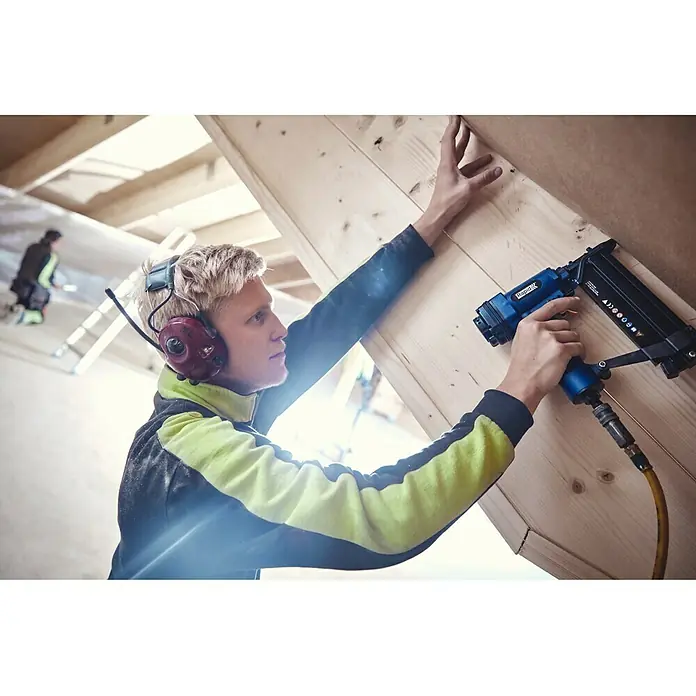 Rapid Nagel Typ 8 - Länge: 50 mm, 5.000 Stk., Verzinkt - Ein Handwerker befestigt mit einem blauen Druckluftnagler Holzlatten. Der Nagler ist das zentrale Element im Bild.