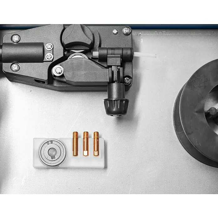 Güde Fülldrahtschweißgerät SG 131 A-SYN - Schweißstrom: 20 A - 120 A, 230 V - Nahaufnahme einer MIG-Schweißmaschine mit Drahtvorschub und Düsen. Wichtige Werkzeuge für präzises Schweißen.