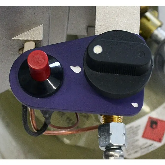 Güde Gasheizstrahler GHS 4200 M PIEZO - 3,2 kW - 4,4 kW - Nahaufnahme eines Geräts mit einem roten Knopf und einem schwarzen Drehknopf auf einer violetten Platte.