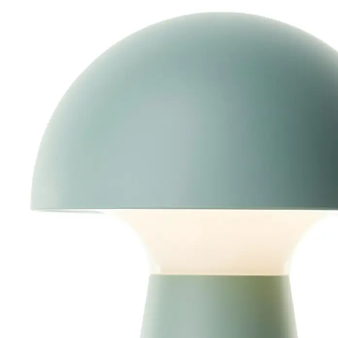 Brilliant Akku-Tischleuchte Navabi - 1,5 W, 9,5 x 17,9 cm, Grün, Warmweiß - Nahaufnahme einer mintgrünen Tischlampe mit einem glockenförmigen Schirm, die ein sanftes, warmes Licht ausstrahlt.