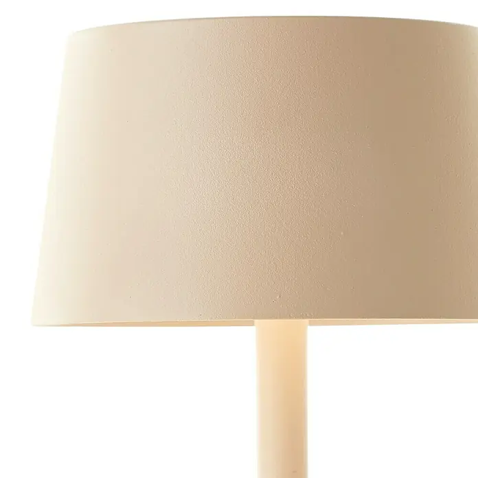 Brilliant Akku-Tischleuchte Jona - 2 W, 9 x 25 cm, Beige, Warmweiß - Nahaufnahme einer cremefarbenen Tischlampe mit Stoffschirm. Das schlichte Design sorgt für ein angenehmes, warmes Licht im Raum.