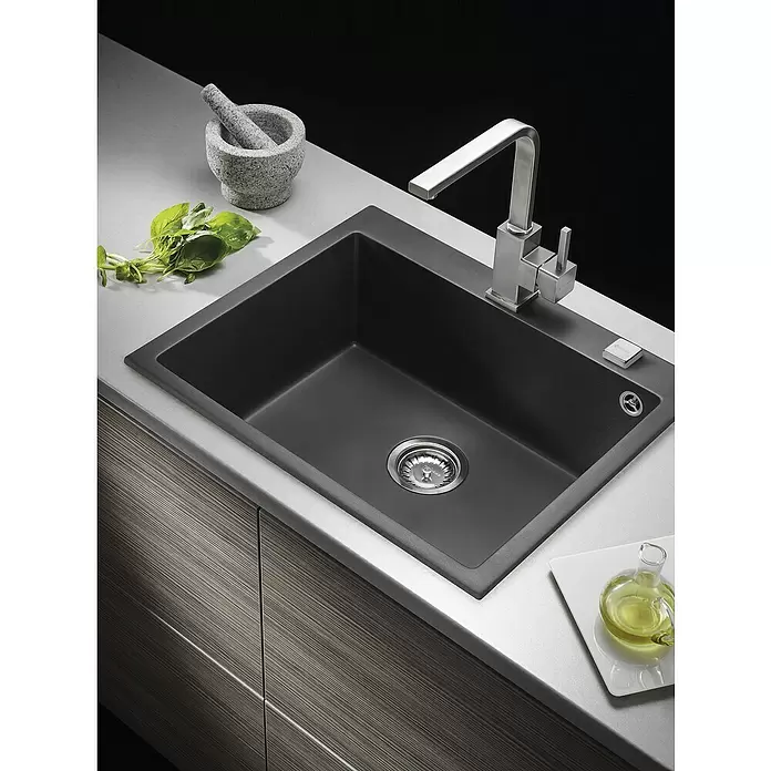 Pyramis Einbauspüle Istros - B x L: 61 x 50 cm, Schwarz - Dunkelgraues Küchenspülbecken mit Edelstahlarmatur, in eine hellgraue Arbeitsplatte integriert, umgeben von Küchenutensilien.