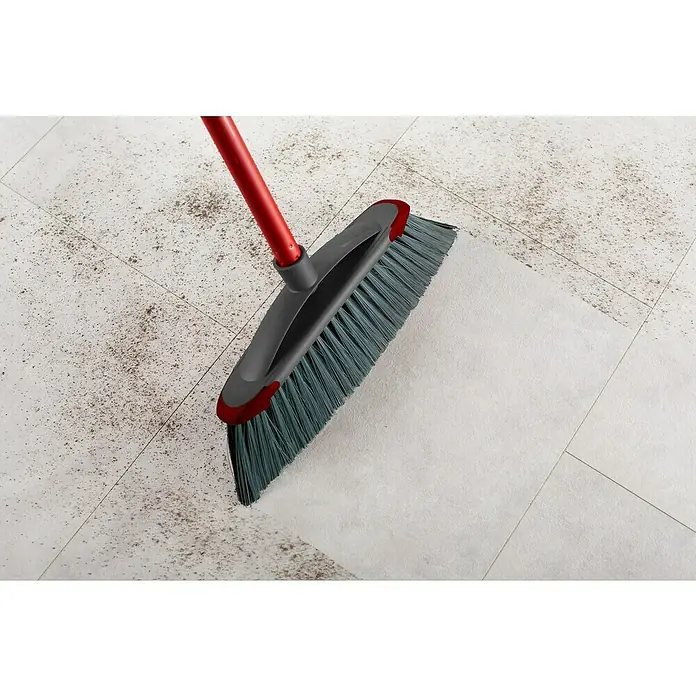 Vileda Zimmerbesen Classica 2in1 Besen - Material Borsten: Recyceltes PET, Breite Besen: 34 cm - Ein roter Besen mit grauen Borsten kehrt Schmutz von einem hellen Fliesenboden und sorgt für Sauberkeit und Ordnung im Raum.