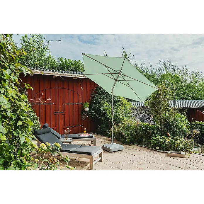 Suncomfort Marktschirm Shell-Turn - Frost Grün, Durchmesser Bespannung: 300 cm - Eine grüne Ampelschirm spendet Schatten auf einer Terrasse mit Liegestühlen, ideal für entspannte Stunden im Freien.