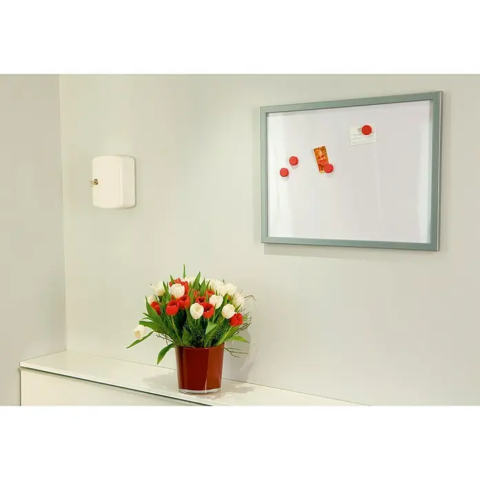 Tesa Powerbond Montageband Indoor - 5 m x 38 mm - Ein helles Interieur mit einem Blumenstrauß roter und weißer Tulpen in einer roten Vase, einem Whiteboard und einem Schlüsselschrank.