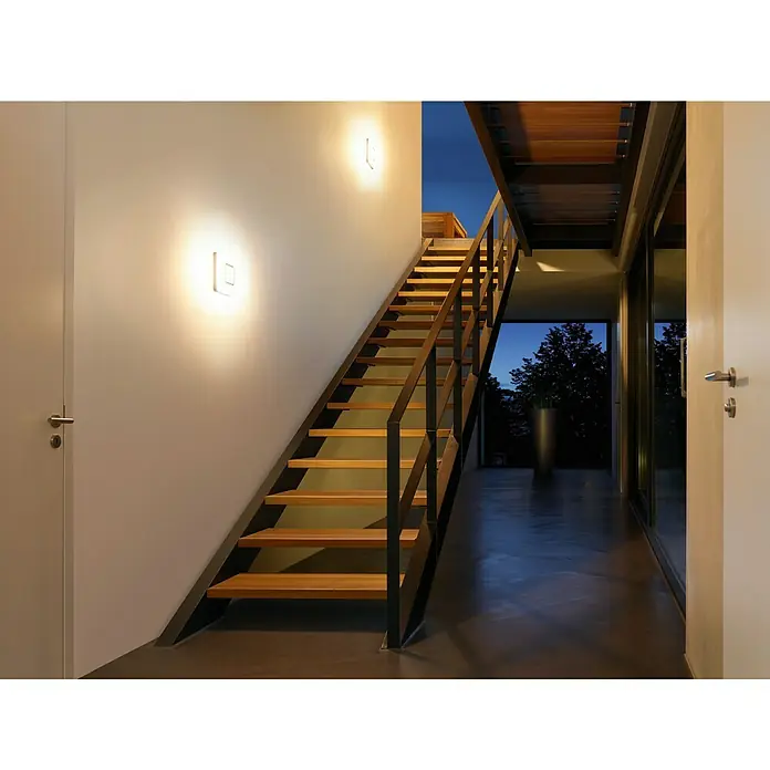 Steinel Sensor-Wand- & Deckenleuchte RS LED M1 S Edelstahl - 8,8 W, L x B x H: 20 x 20 x 5,3 cm, Weiß - Moderne Innenarchitektur mit einer Treppe und Wandleuchten, die ein warmes Licht verbreiten. Stilvolles Design für ein gemütliches Ambiente.