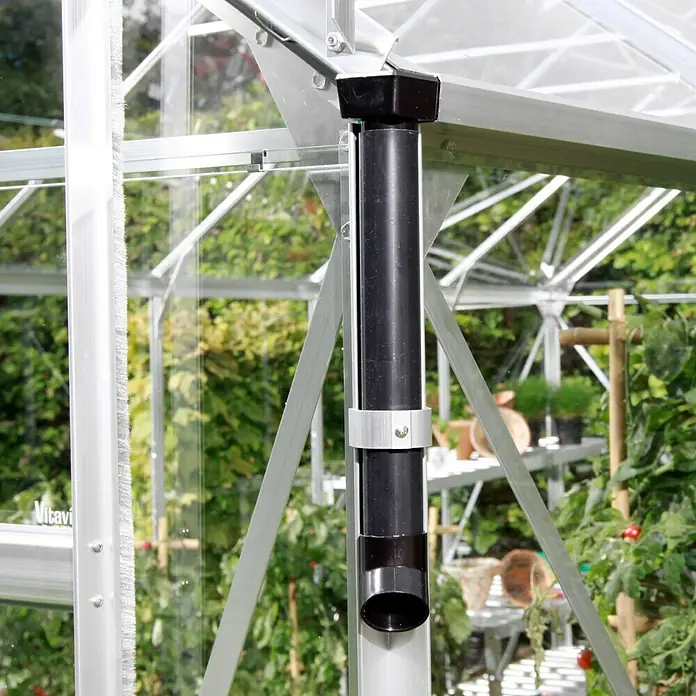 Vitavia Gewächshaus Venus 5000 Plus - Außenmaß inkl. Dachüberstand (B x T): 195 x 257 cm, 3 mm, Smaragd - Nahaufnahme eines schwarzen Regenrohrs an einem Gewächshaus, das Regenwasser ableitet. Es wird mit einer Metallschelle an der Rahmenstruktur befestigt.