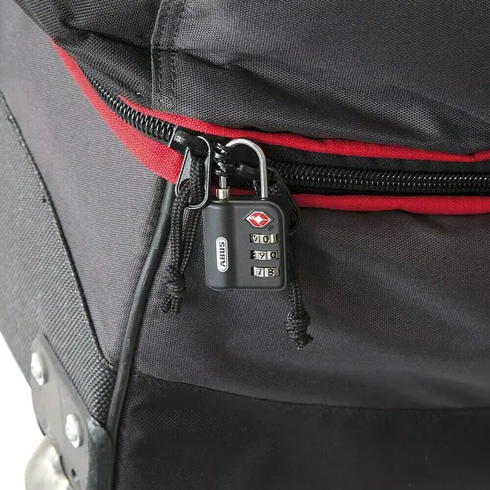 Abus Vorhängezahlenschloss 147 TSA - L x B x H: 14 x 33 x 60 mm, Zahlenschloss mechanisch - Nahaufnahme eines schwarzen ABUS-Zahlenschlosses an einem Reißverschluss eines grauen Koffers mit roten Akzenten.