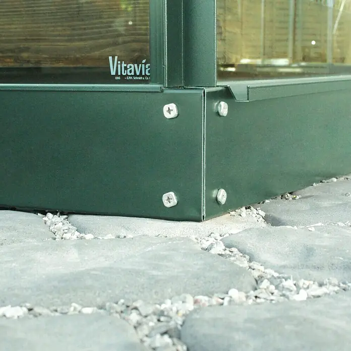Vitavia Gewächshaus Venus 5000 Plus - Außenmaß inkl. Dachüberstand (B x T): 195 x 257 cm, 3 mm, Smaragd - Nahaufnahme einer grünen Vitavia-Gewächshausbasis mit silbernen Schrauben auf einem Steinsockel.